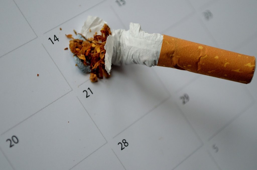 Image of a cigarette stubbed out on a a calendar.