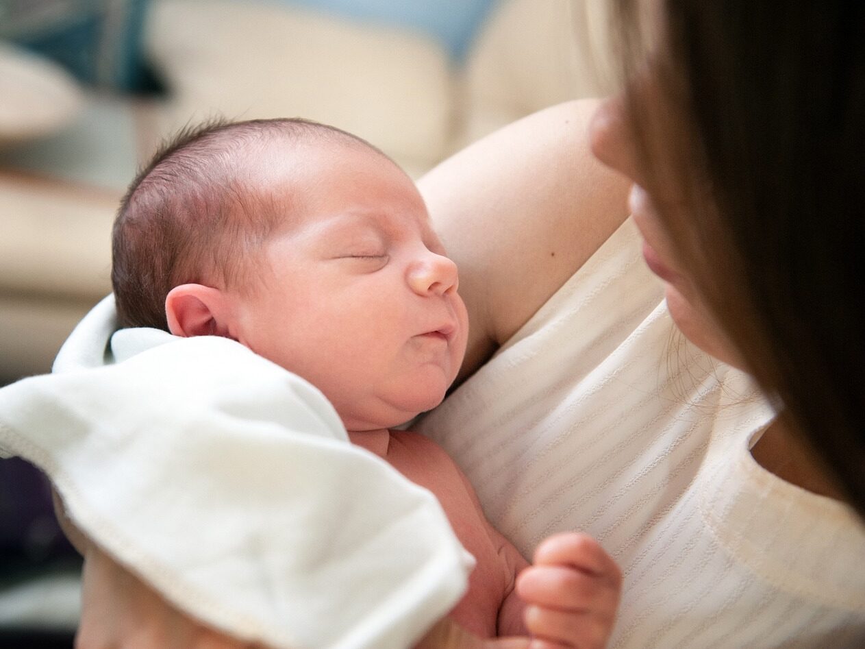 Parent holding their new born baby.