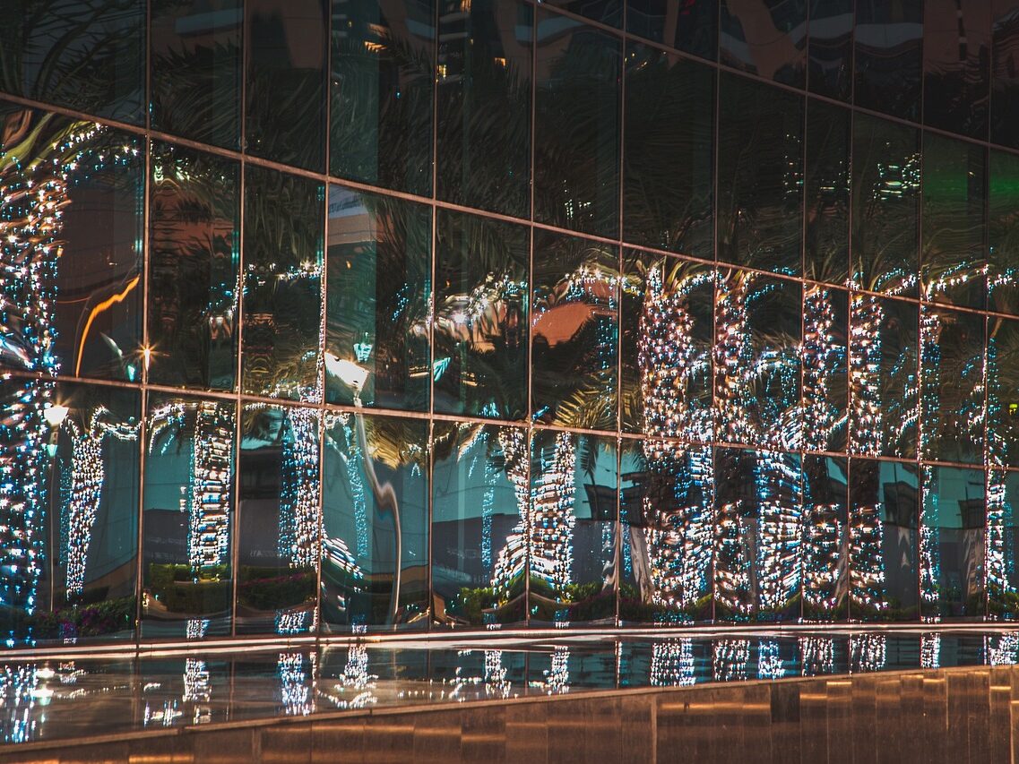 Lights reflected in a distorted way in the glass windows of a building.