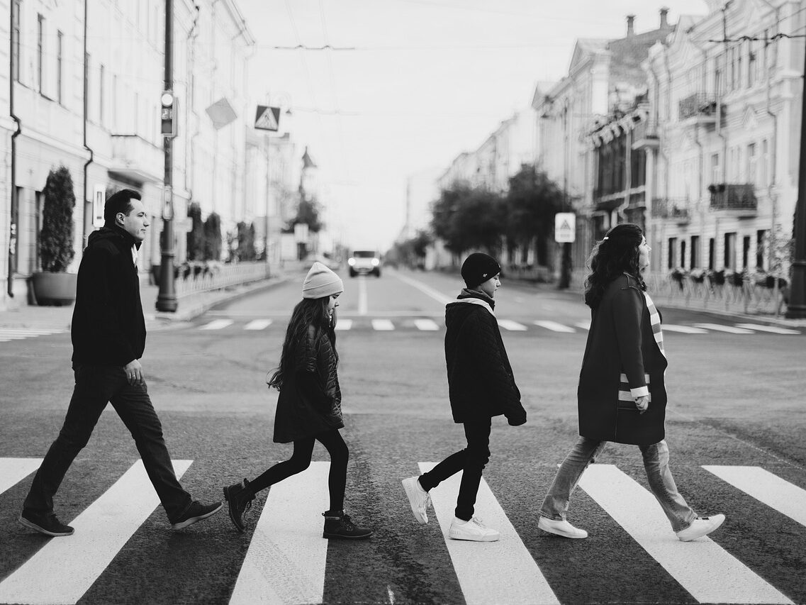 Family crossing a road at a Zebra crossing.