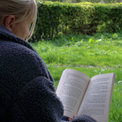 woman reading a book on the grass